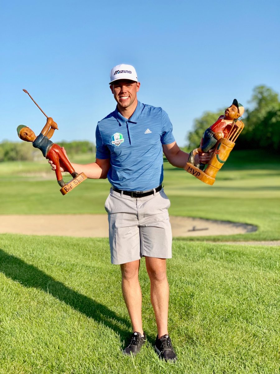 Andrew on the golf course holding two trophies